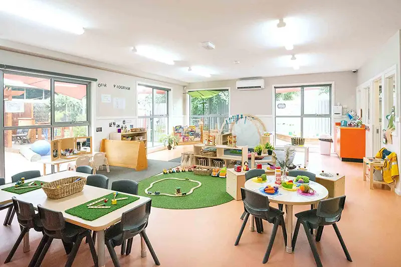 kindergarten room with tables and train set