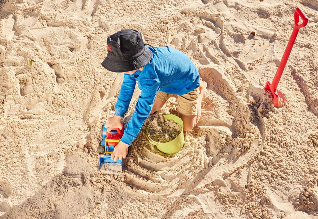 Mermaid Waters Kindergarten boy playing with a truck in sandpit.